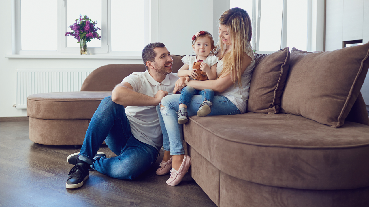 family of three sitting together in living room
